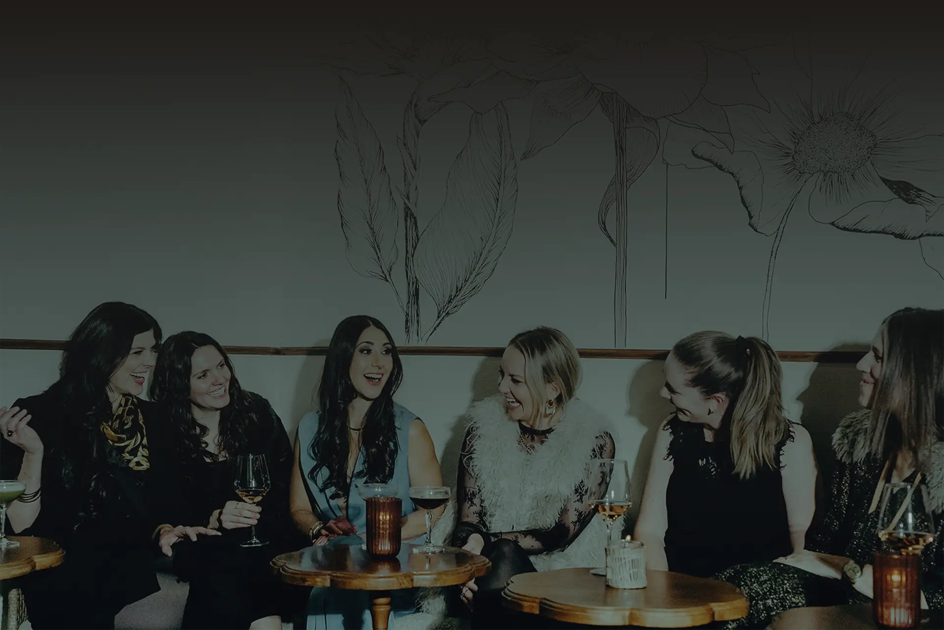 Moms laughing together around a table at an MFT event